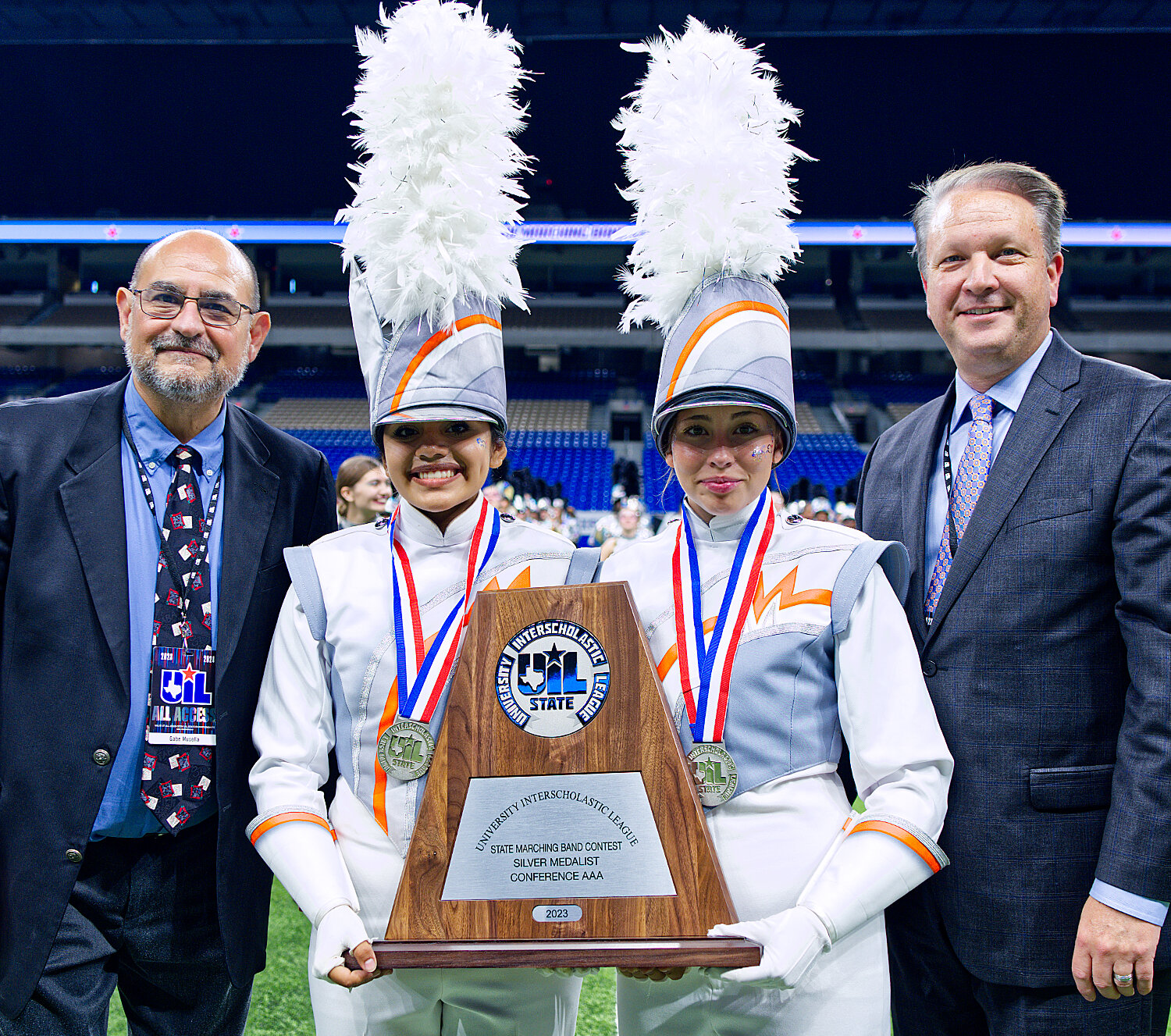 Mineola drum majors Marianna Delgadillo, left, and Jada Woodward are congratulated by UIL Assistant Music Director Gabe Musella, left, and Music Director Dr. Bradley Kent as the 2023 Conference 3A silver medalist in state marching. [see several more swarm shots]
